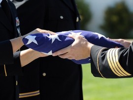 Military flag presentation ceremony at a Veteran’s memorial