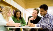 Students studying together with a tutor at a table