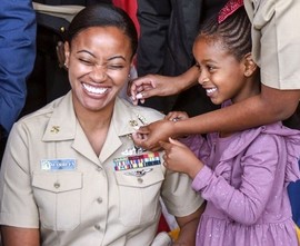 Navy chief petty officer's daughters help pin anchors to her uniform