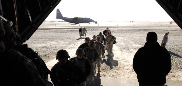 Service members embark a C-130H Hercules aircraft