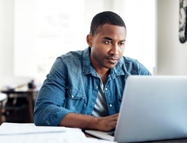 Man using the GI Bill Comparison Tool on his laptop