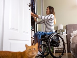 Disabled woman at home sorting through her closet