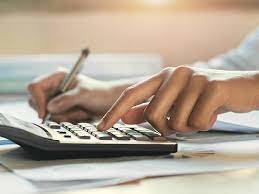 hands working on a calculator while taking notes