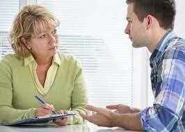 counselor takes notes while speaking with student