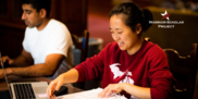 female student smiling while working on coursework