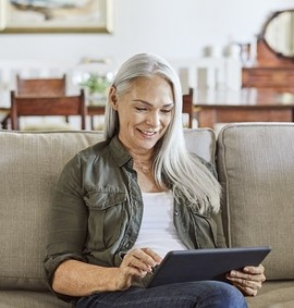 Woman reading about the Affordable Connectivity Program on her tablet