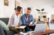 female sitting with male planning for the future in front of computer