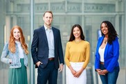 Close up of four office workers standing in office building