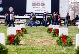 Volunteers carry wreaths during the annual Wreaths Across America event in Arlington National Cemetery