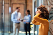 woman with her back against the wall and hands on her head