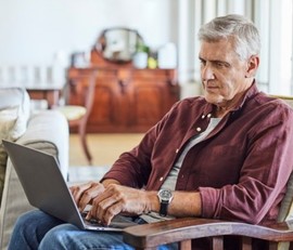 Mature man tracking his VA claim online with his laptop