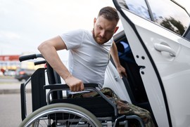 Man in wheelchair getting into his adapted vehicle