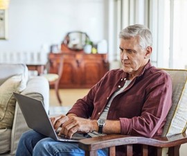 Mature man tracking his VA claim online with his laptop