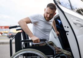 Man in wheelchair getting into his adapted vehicle