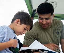 Service member reading to his son