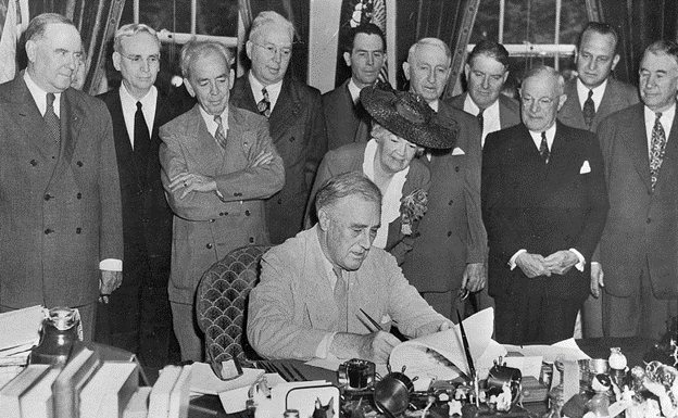Members surround President Franklin D. Roosevelt as he signs the GI Bill into law.