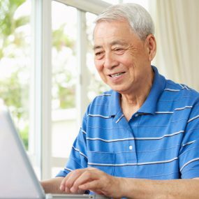 Man sits while typing on a laptop
