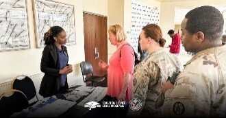 Department of Veterans Affairs member helps students at a table