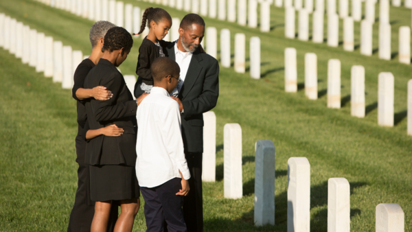 Multi-generational family at a gravesite in a national cemetery