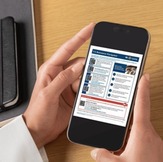 Hands holding a cell phone displaying the VA Resource Navigator screen