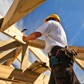 man hammering on rafters