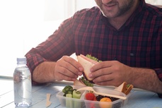 Man eating healthy food from lunch box 