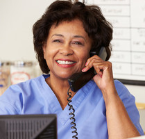 A smiling nurse talking on the phone.