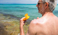 Veteran applying sun lotion at beach