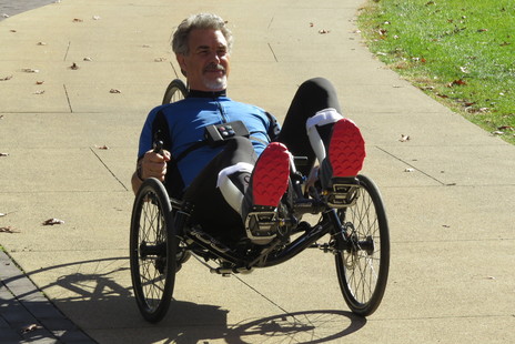 Man with spinal cord injury riding a bike outside