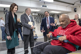 Drs. Ramoni and Fallon listen to Dr. Triolo explain about his new exercise program for paralyzed Veterans while a subject demonstrates the machine
