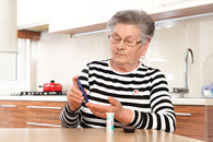 A Veteran checking her blood sugar at home