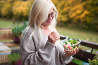 A Veteran eating a salad in her back yard