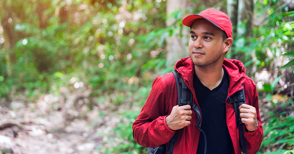 A man walking on a trail in a forest.