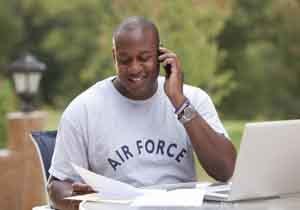 Veteran on phone in front of laptop