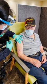 older man receiving shot from nurse