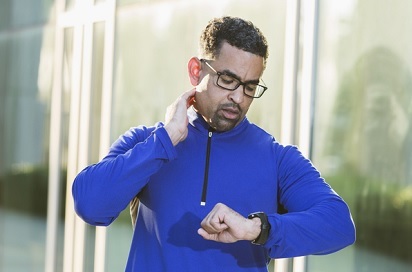 A Veteran checking his heart rate while running