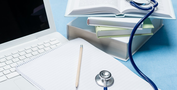 laptop notebook pen stethoscope and books