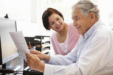A Veteran and his caretaker looking over documents 