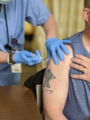 Veteran receives COVID vaccine in arm