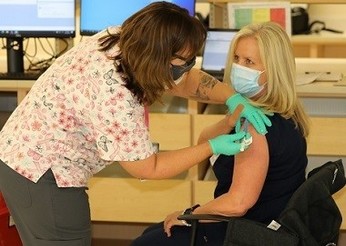 A woman getting the COVID-19 vaccine through VA