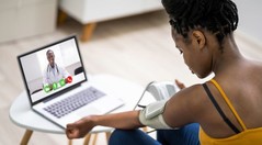 A young woman using a blood pressure monitor