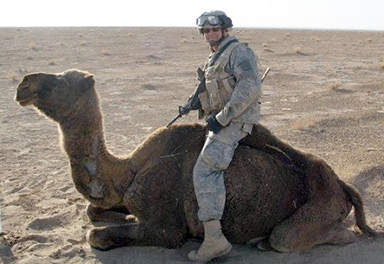 Man in military uniform sitting on a camel's back