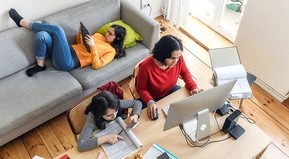 three women working separately on laptop, iPad, and taking note