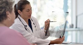 female physician showing woman an x-ray