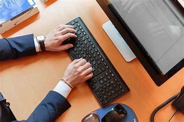 Person's hands typing on computer keyboard