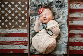 Baby with dog tags sleeping on daddy’s uniform