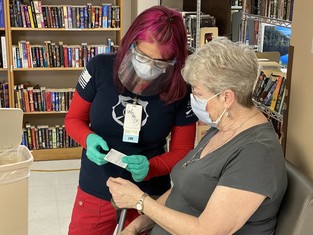 A Veteran learning more about her COVID-19 vaccine card