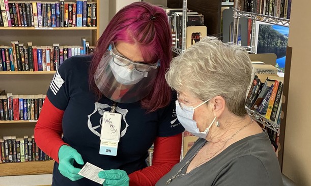 A Veteran learning more about her COVID-19 vaccine card