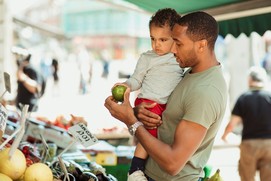 Man holding child inspecting apple