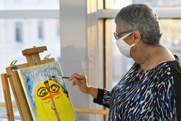 Female Veteran invites view of her painting